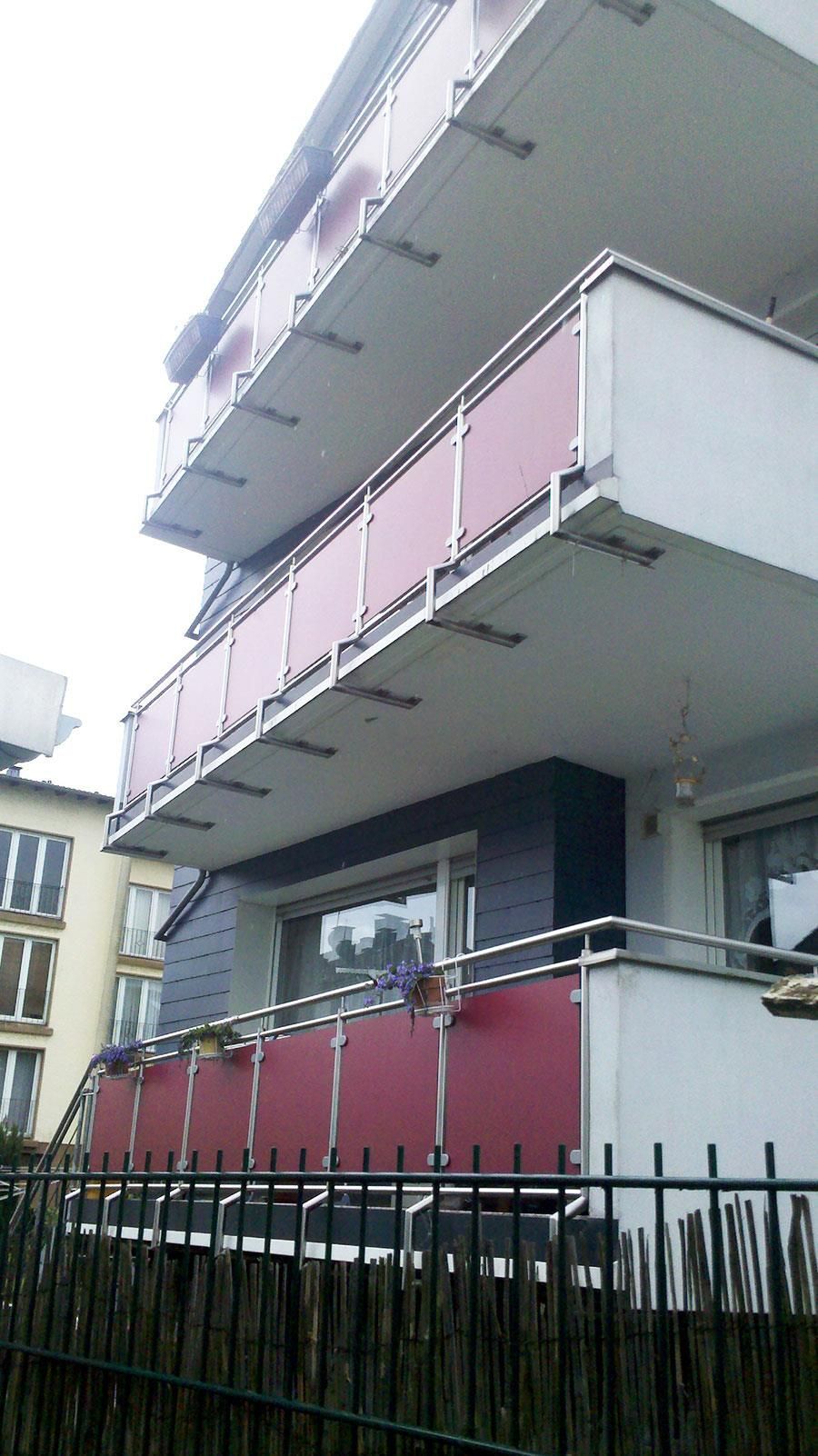 Ein Gebäude mit einem Balkon und einem Zaun davor