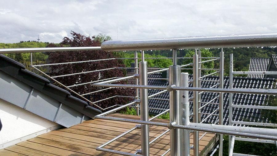 Ein Balkon mit Edelstahlgeländer und einer Treppe, die dorthin führt.