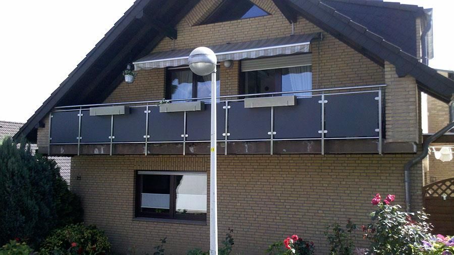 Ein Backsteinhaus mit Balkon und einer Straßenlaterne davor