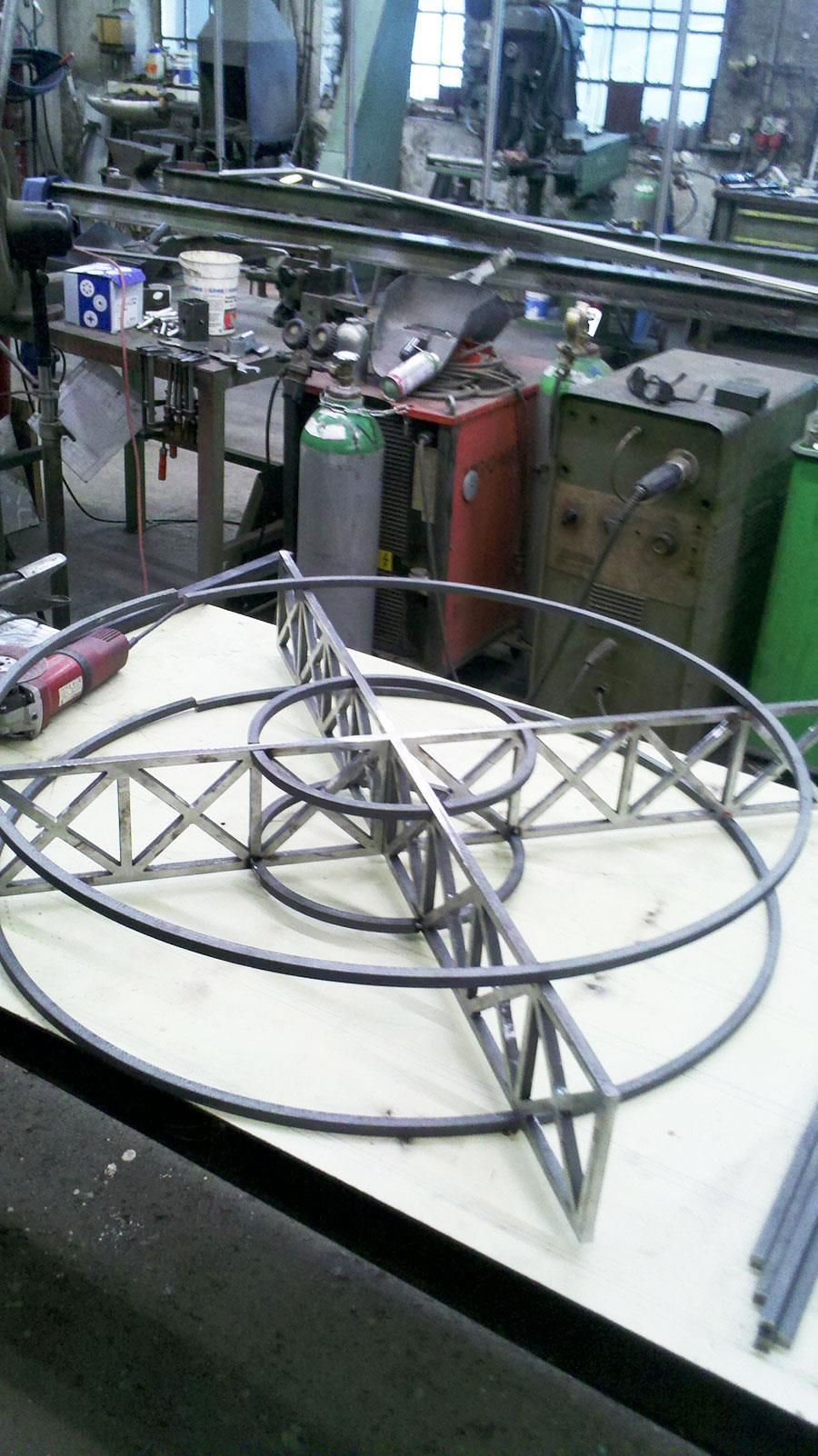In einer Werkstatt steht eine kreisförmige Metallstruktur auf einem Tisch.