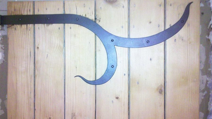 Ein Stück Metall ist an einer Holzwand befestigt