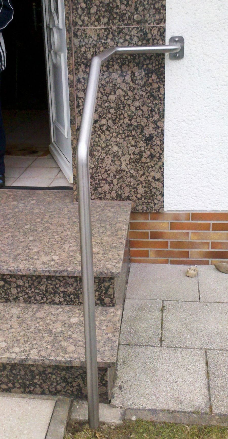 An der Seite einer Treppe ist ein Edelstahlgeländer angebracht.