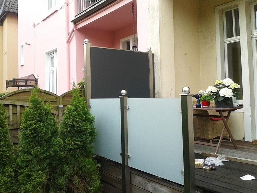 Ein Balkon mit einem Zaun und einem Tisch mit Blumen darauf