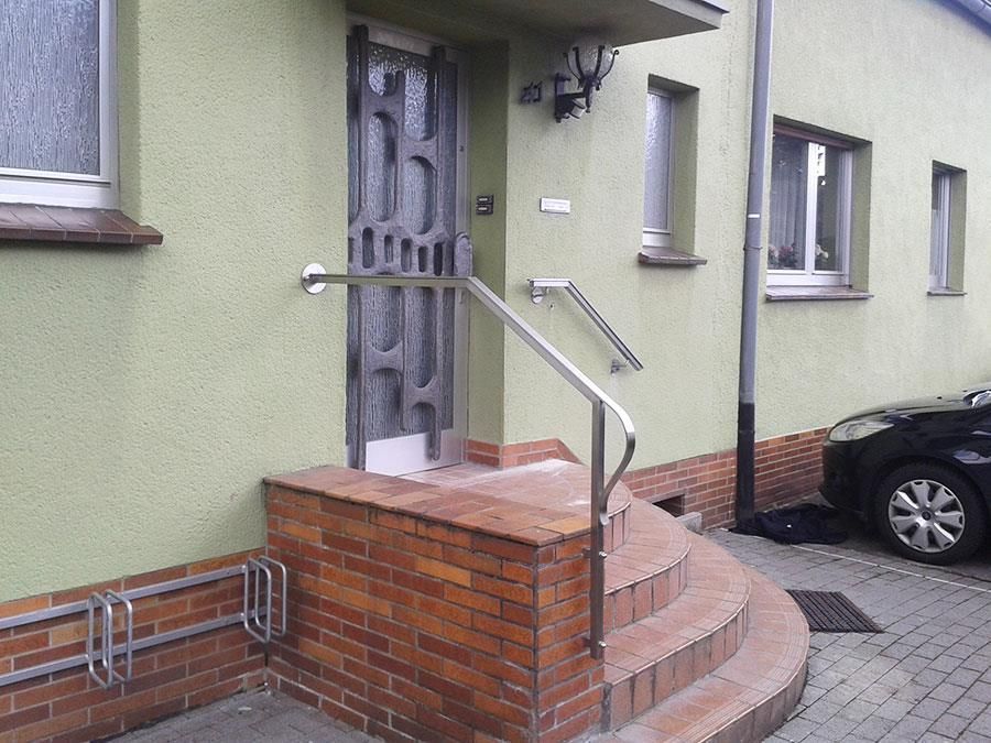 Ein grünes Haus, vor dem ein schwarzes Auto geparkt ist.