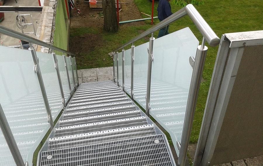 Eine Treppe mit Edelstahlgeländer und Glasgeländer
