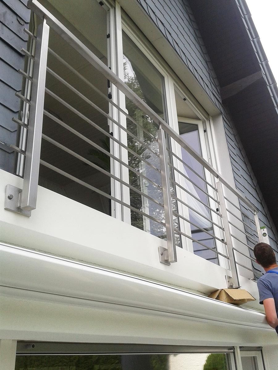 Ein Mann steht auf einem Balkon eines Hauses