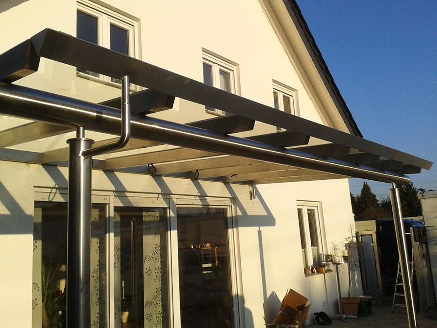 Ein weißes Haus mit einer Pergola an der Seite