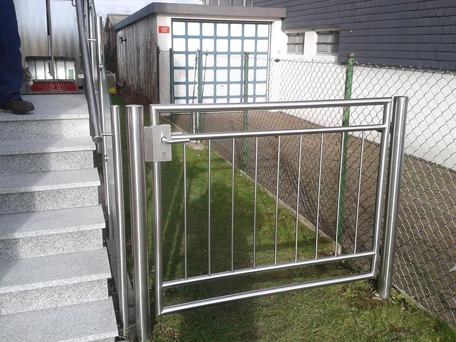 Ein Edelstahltor mit Treppen im Hintergrund