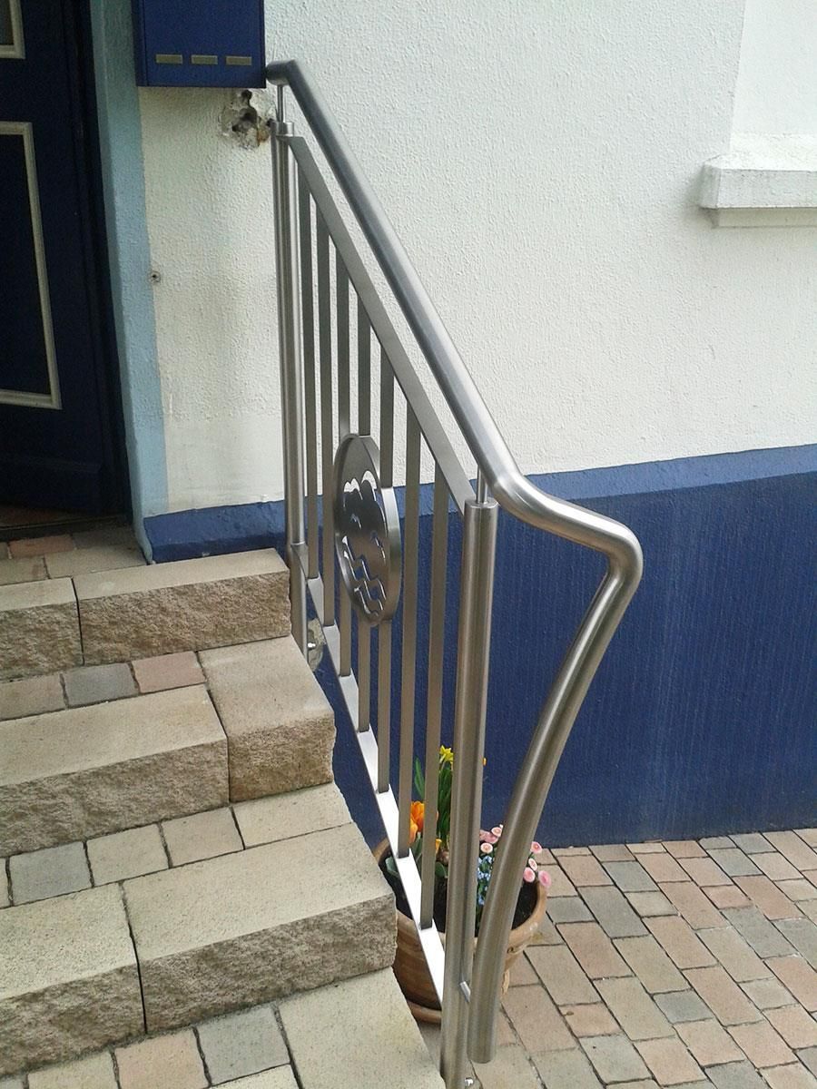 Eine Treppe mit einem Edelstahlgeländer und einer blauen Tür