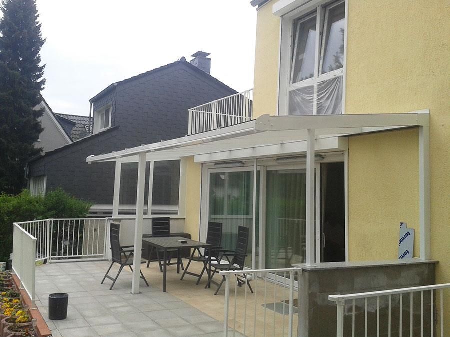 Ein gelbes Haus mit einer Terrasse mit Tisch und Stühlen