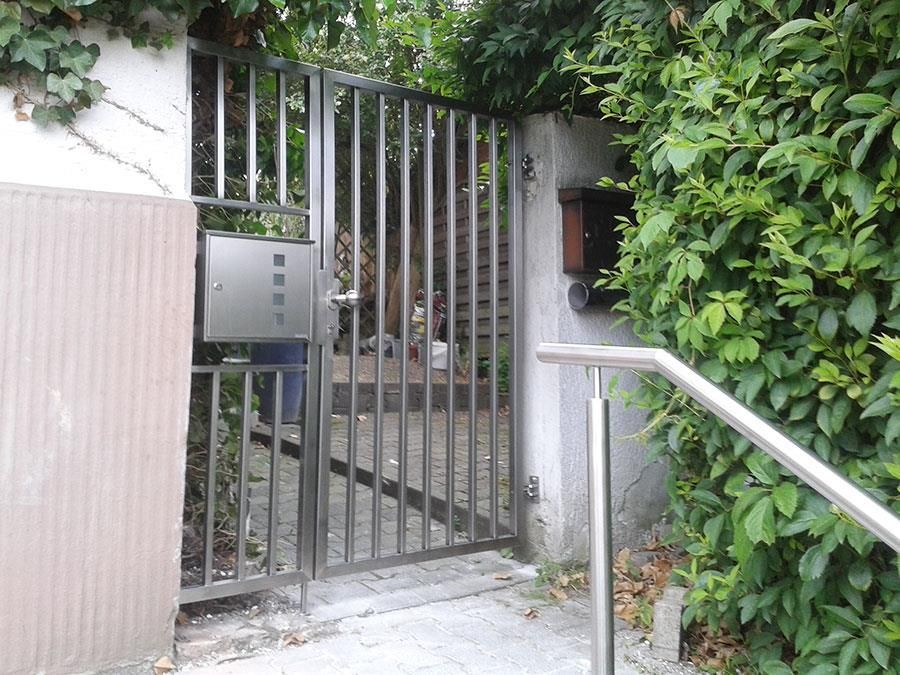 Ein Metalltor mit einem Briefkasten dahinter