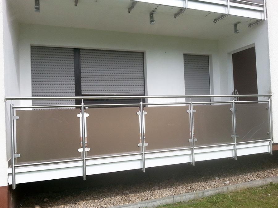 Ein Balkon mit Edelstahlgeländer und braunem Glas