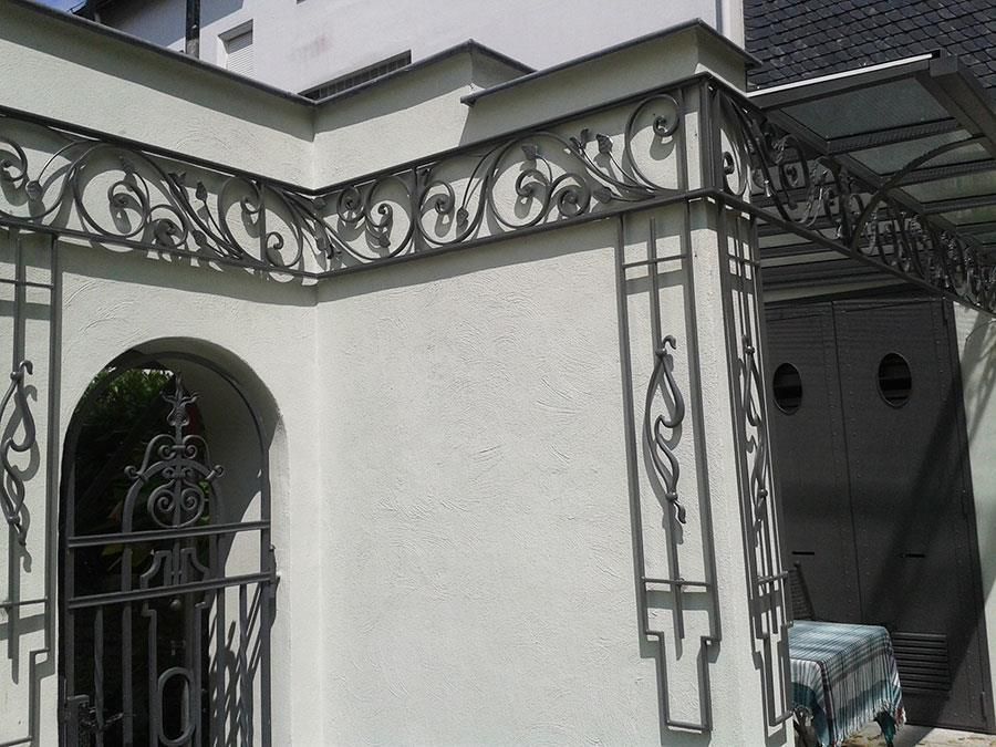 Ein weißes Gebäude mit einem schmiedeeisernen Zaun darum