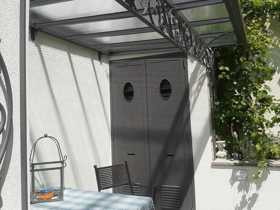 Eine Terrasse mit Tisch und Stühlen unter einem Baldachin