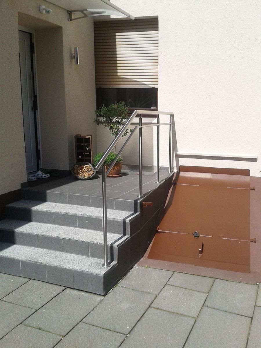 Eine Treppe, die zu einem Gebäude mit einem Edelstahlgeländer führt