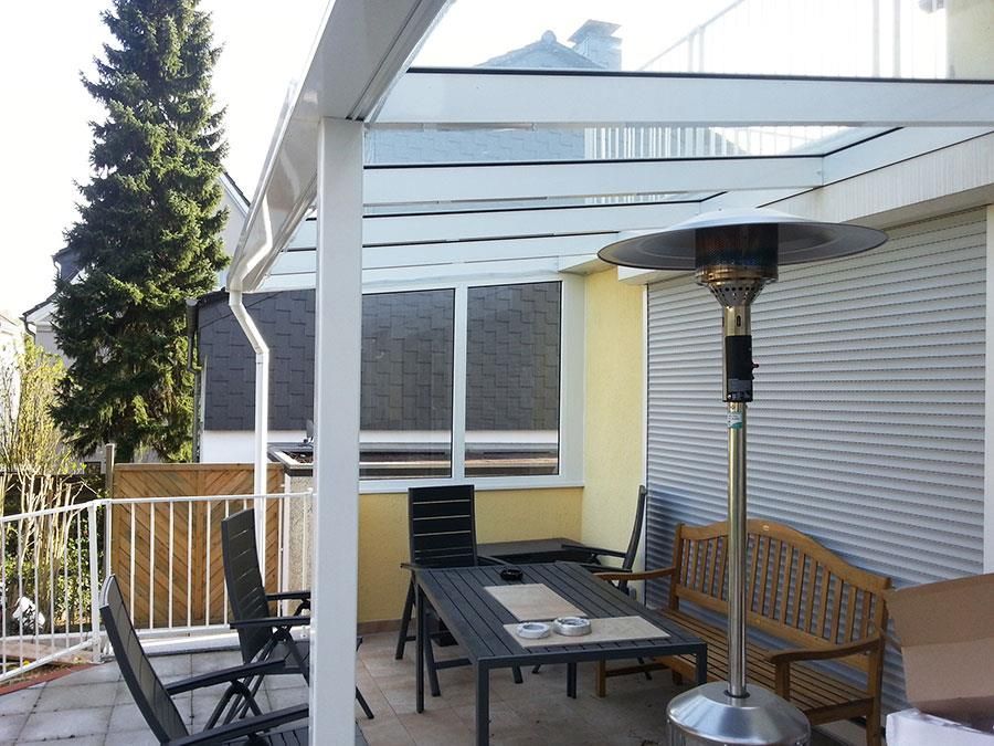 Eine Terrasse mit Tisch und Stühlen unter einem Baldachin