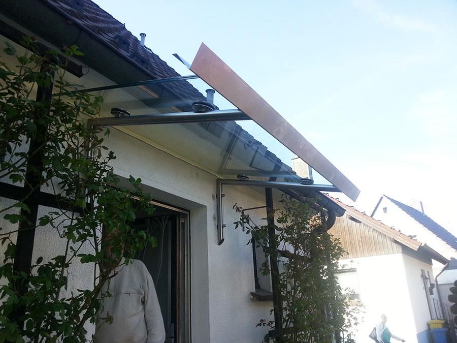 Ein Mann steht vor einem Haus mit einem Vordach auf dem Dach