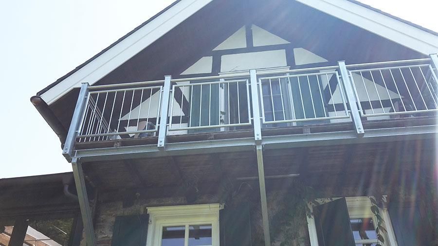 Ein Haus mit einem Balkon auf dem Dach