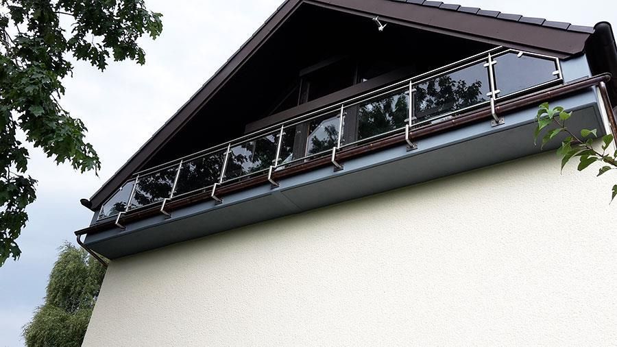 Ein weißes Haus mit einem Balkon auf dem Dach