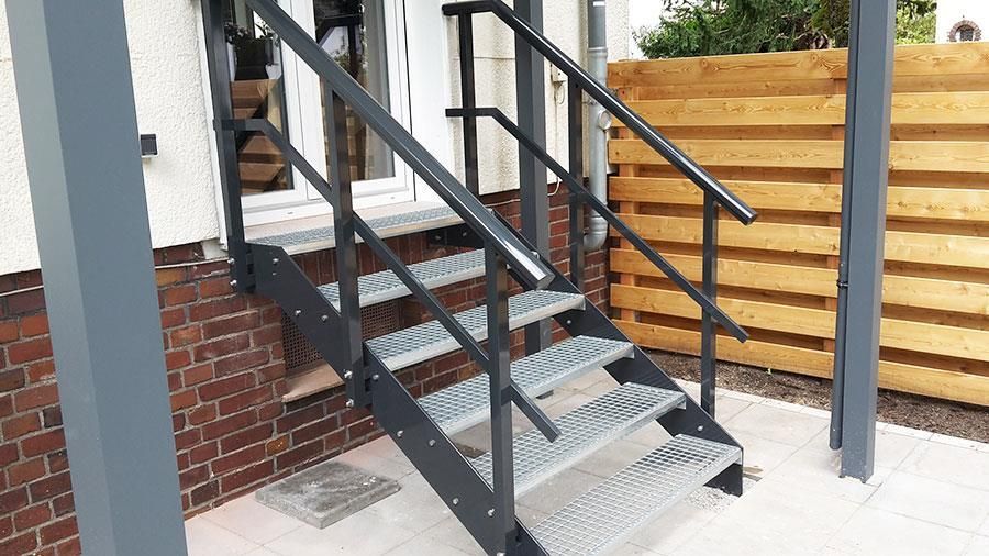 Eine Metalltreppe führt zu einem Backsteingebäude hinauf.