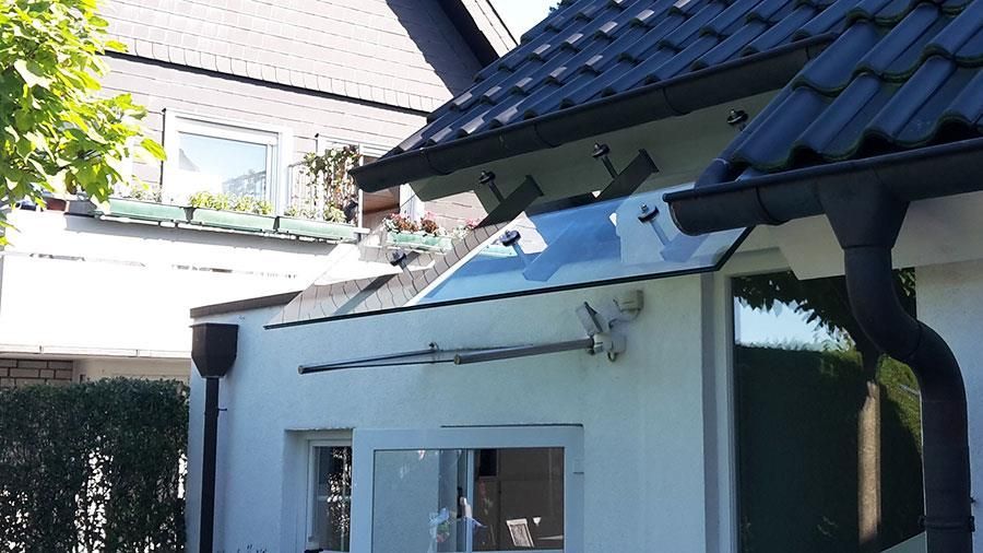 Ein weißes Haus mit schwarzem Dach und Dachrinnen