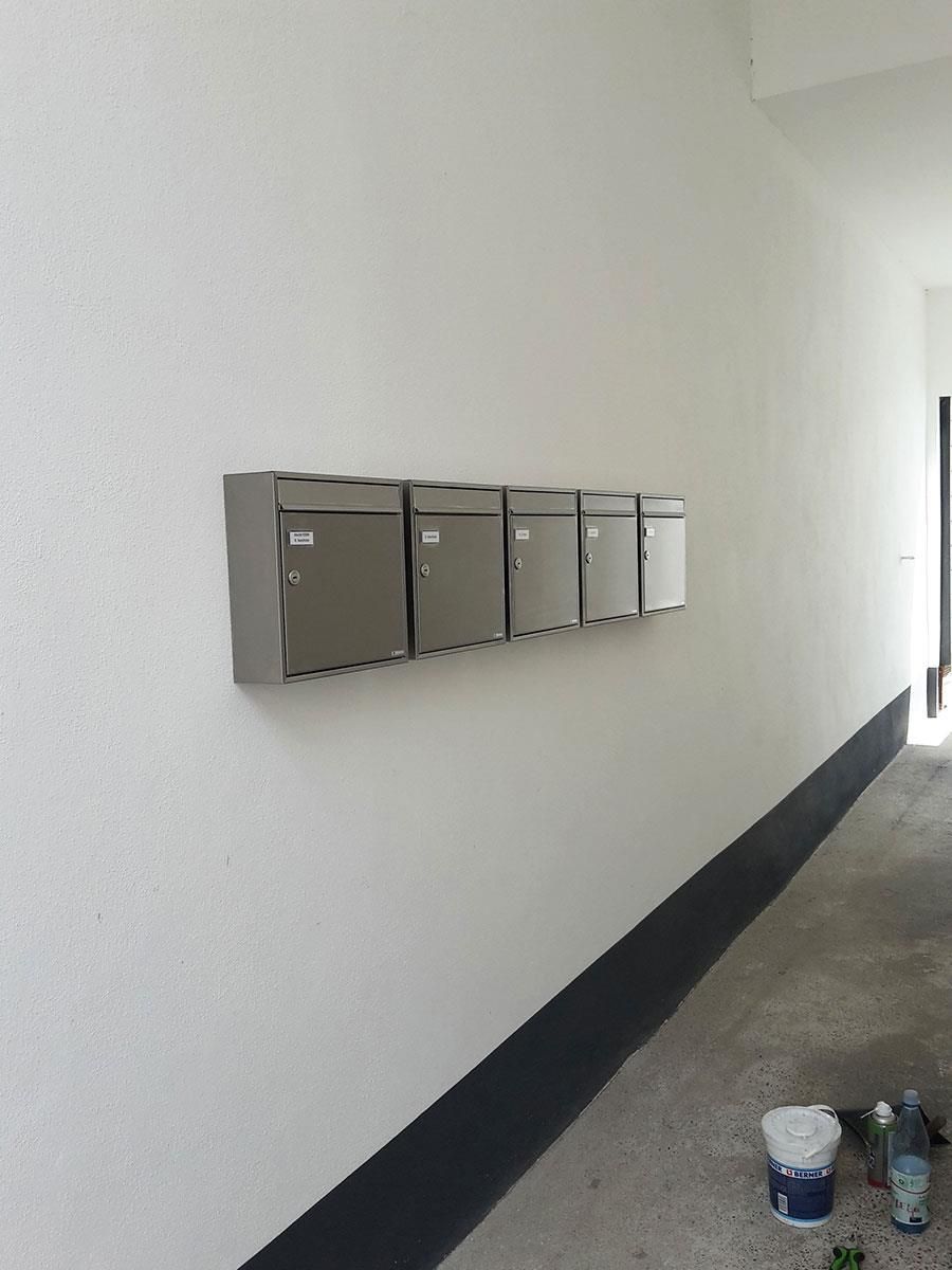 Ein Flur mit einer Reihe von Briefkästen an der Wand.