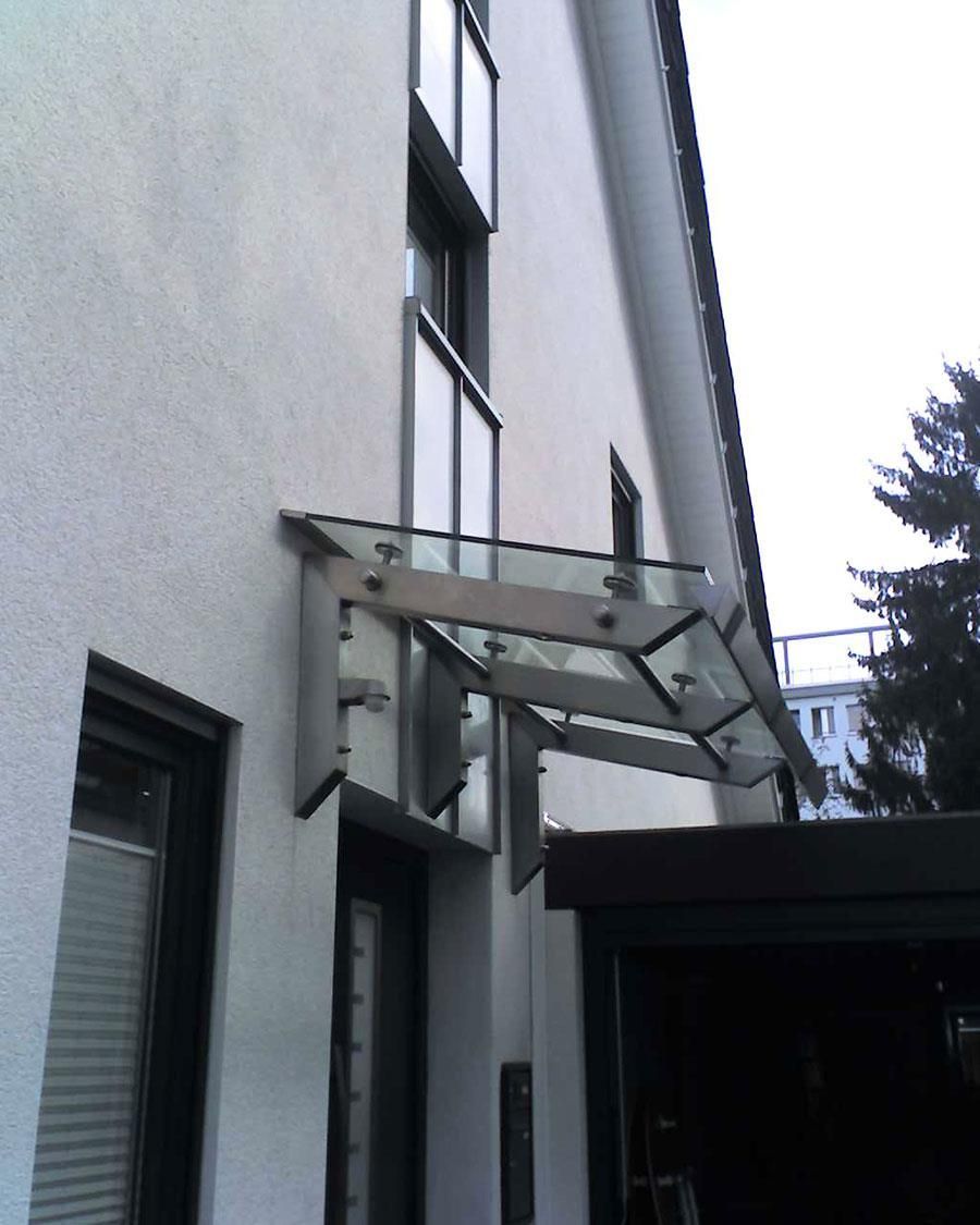 Ein weißes Gebäude mit einem Glasdach über der Tür