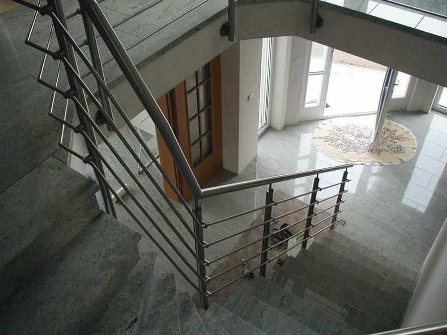 Eine Treppe mit Edelstahlgeländer, die in den zweiten Stock führt