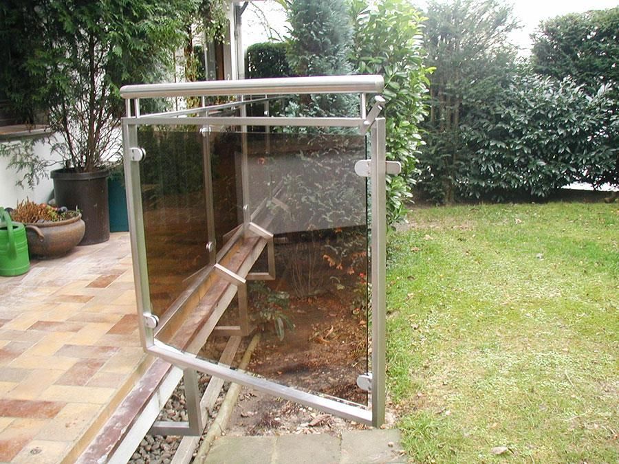 Ein Edelstahlgeländer mit einem Glaszaun im Hinterhof