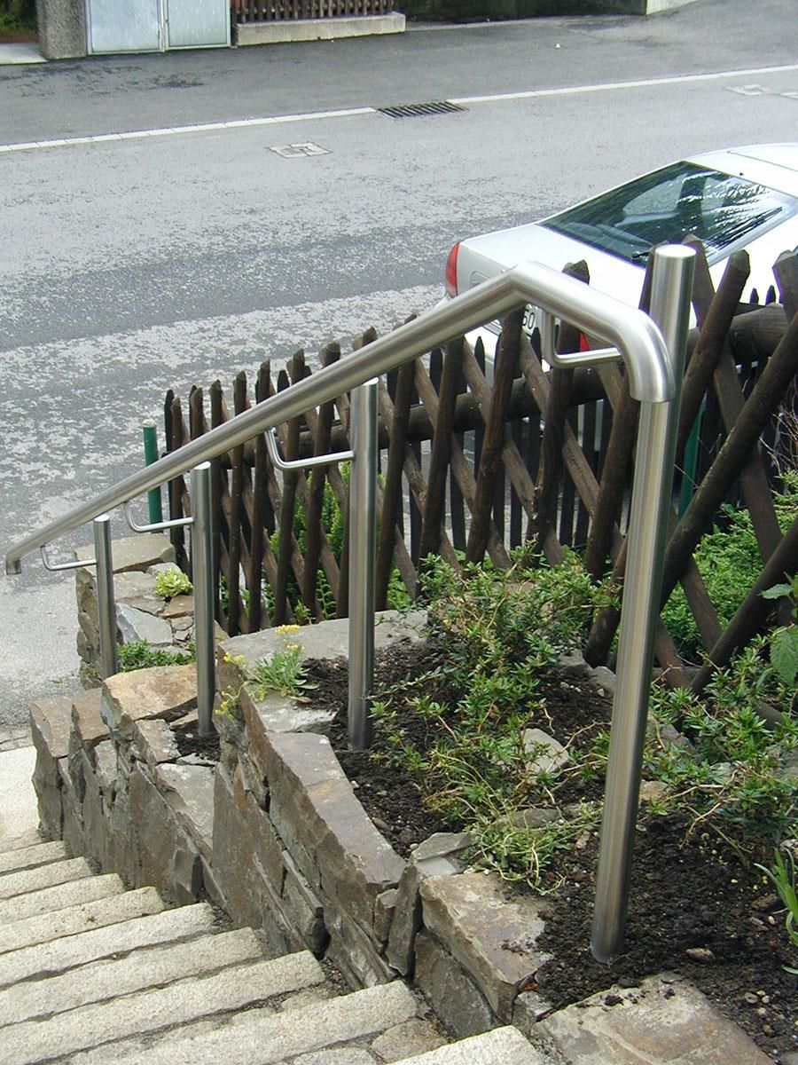 Eine Treppe mit Edelstahlgeländer und Holzzaun