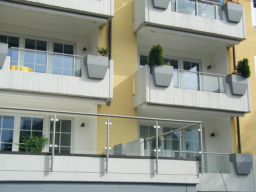 Ein Gebäude mit vielen Balkonen und Pflanzkübeln darauf