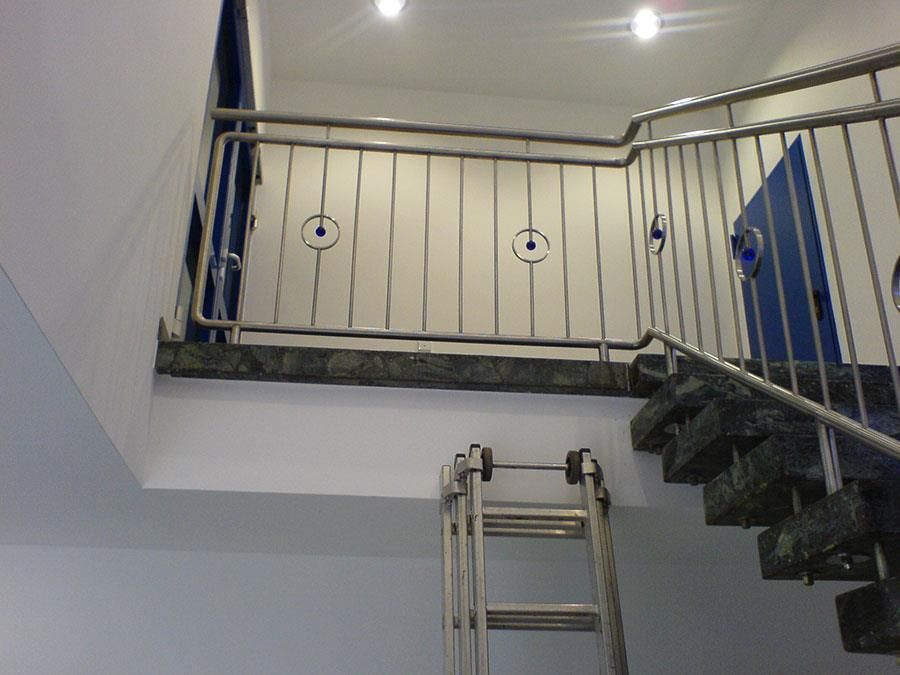 Eine Leiter lehnt am Geländer einer Treppe