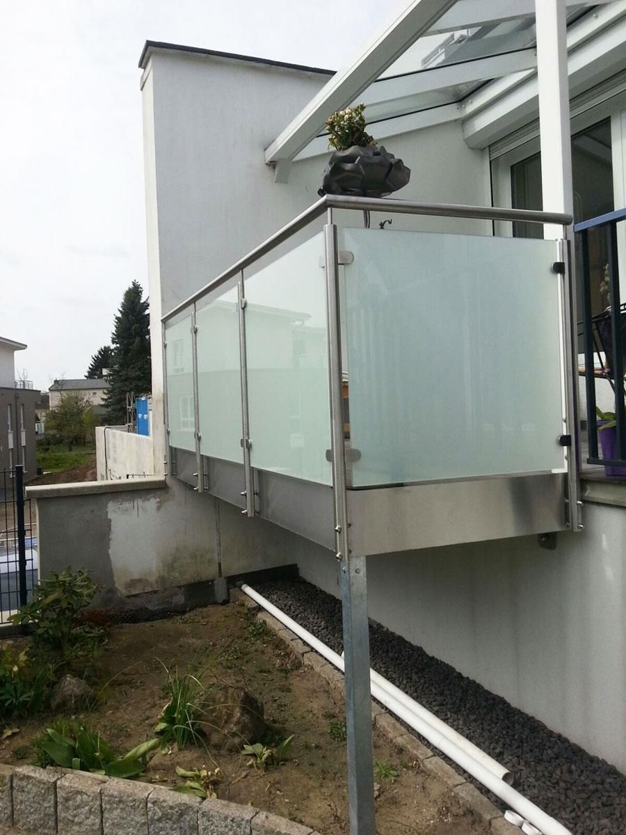 Ein Balkon mit Edelstahlgeländer und Milchglas.