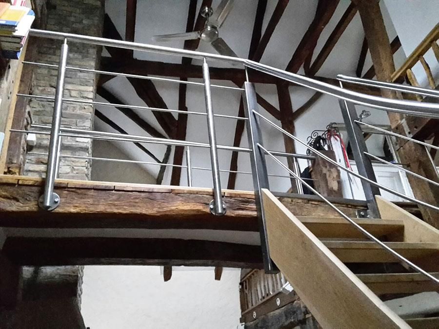 Eine Treppe mit Edelstahlgeländer und Holzstufen