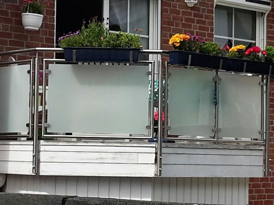 Ein Backsteingebäude mit einem Balkon mit Blumen darauf