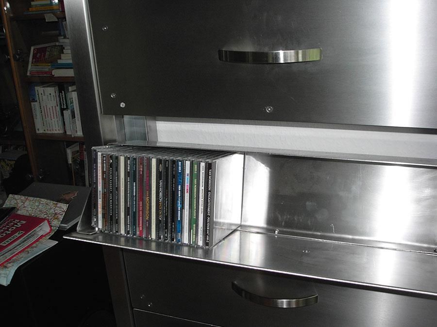 Ein Stapel CDs sind übereinander auf einem Regal gestapelt