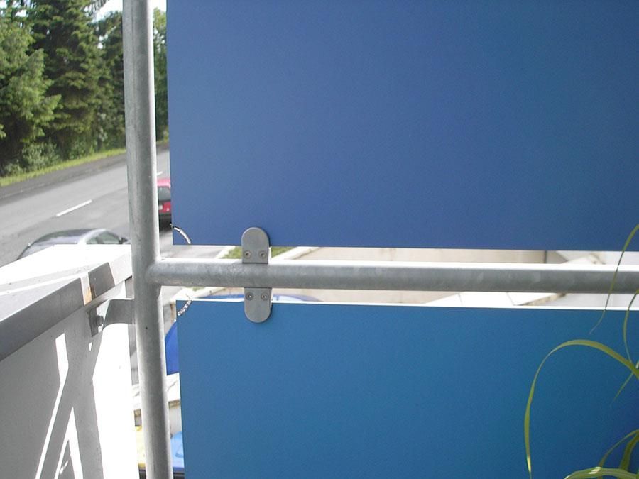 Ein blau-weißer Zaun mit einem Metallgeländer