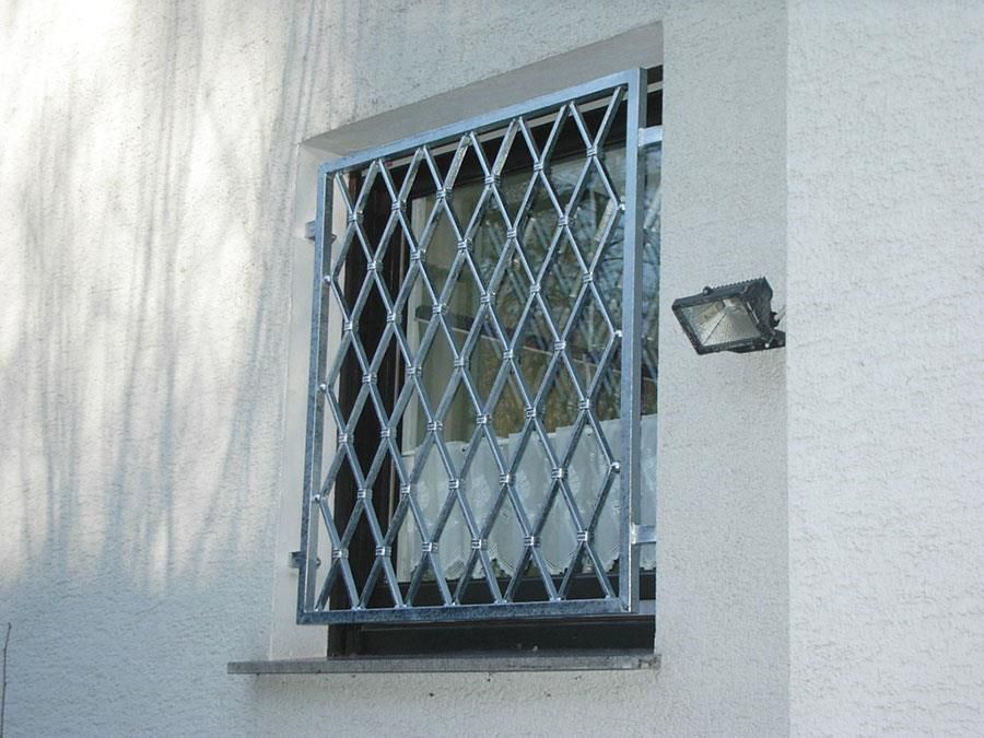Eine weiße Wand mit einem Fenster mit einem Metallgitter darauf