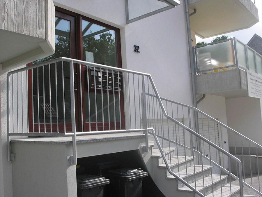 Eine Treppe, die zu einem Gebäude mit einem Metallgeländer führt