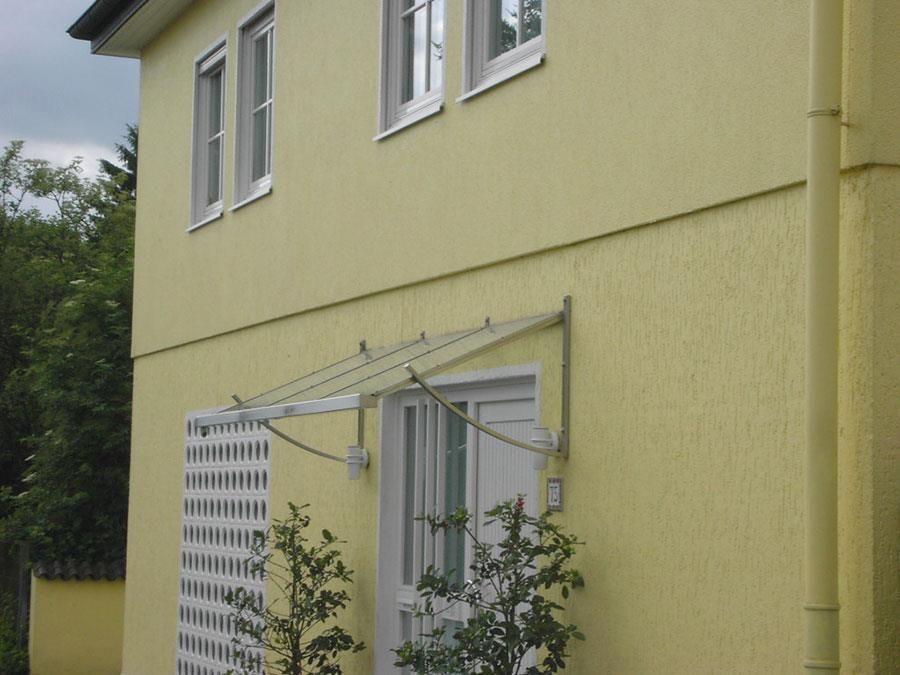 Ein gelbes Haus mit einer weißen Tür und Fenstern