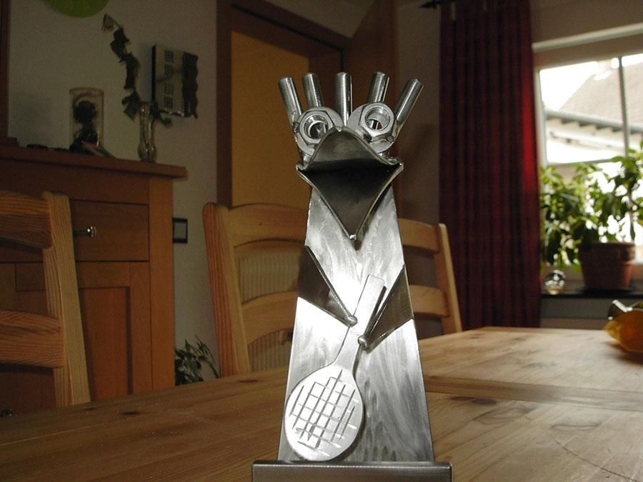 Eine Statue eines Vogels, der einen Tennisschläger auf einem Tisch hält