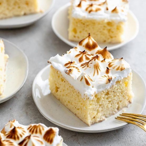 Un trozo de pastel con merengue encima está en un plato con un tenedor.