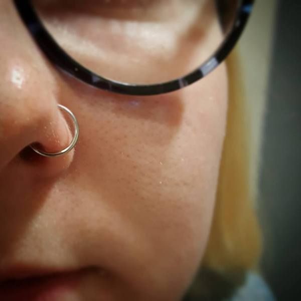 Piercing nez Narine - anneau argent sur une femme à lunettes