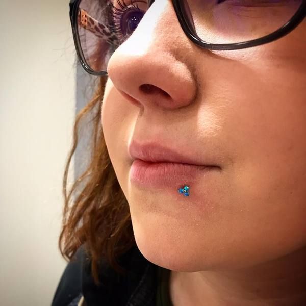 Piercing bouche Labret et Madonna - perle bleue en bas à gauche