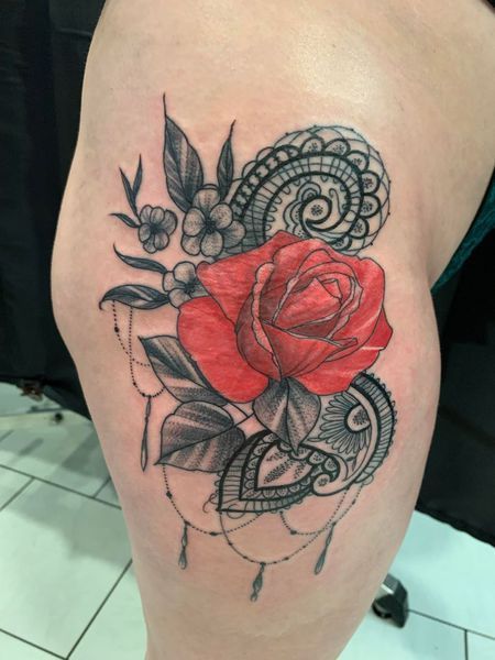 Delphine, tatouage d'une rose rouge sur des motifs noirs