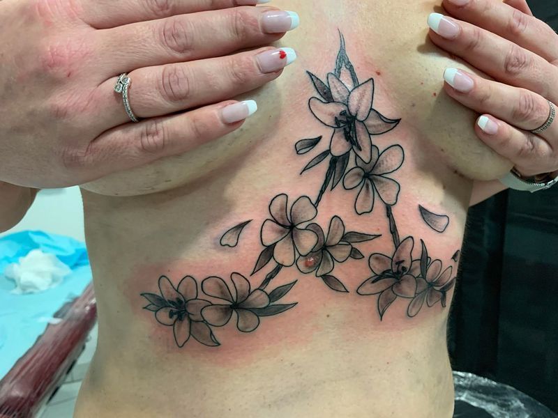 Delphine, tatouage de fleurs sous la poitrine