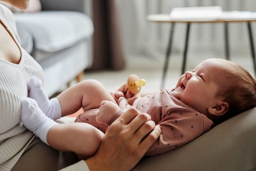 Eine Frau hält ein weinendes Baby in ihren Armen.