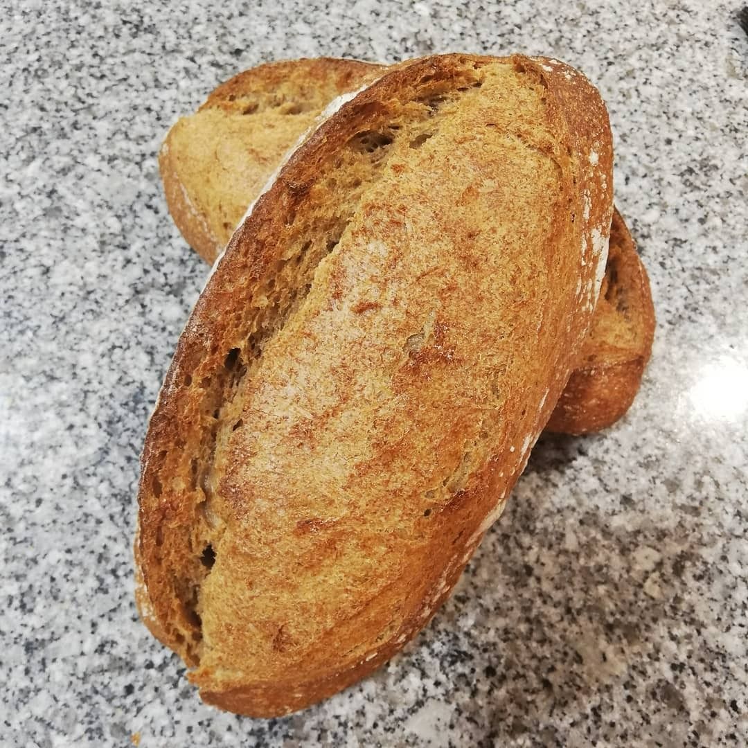 Deux miches de pain complet sur un plan de travail.