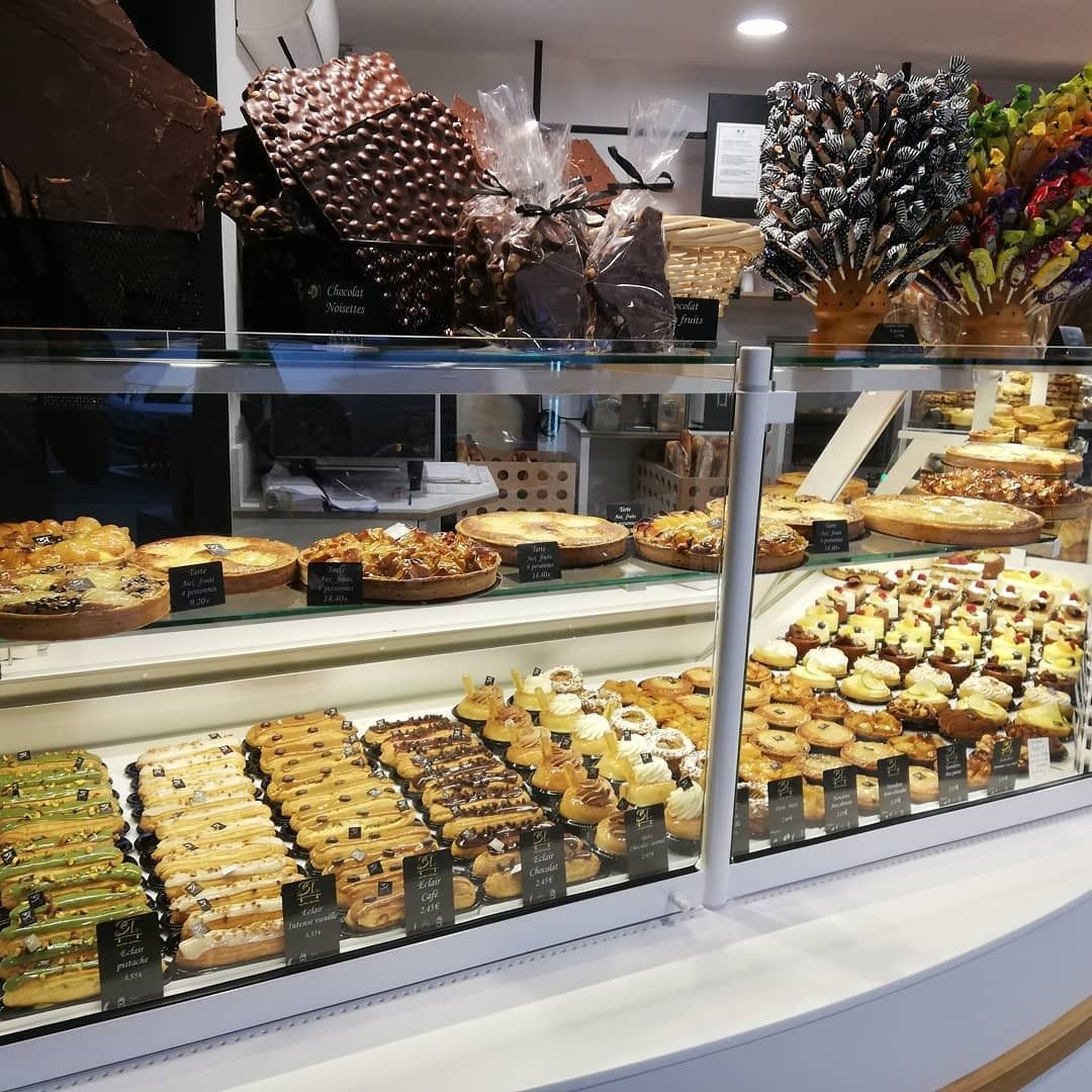Vitrine à pâtisseries remplie de viennoiseries : biscuits, tartes, chocolats. Ambiance boulangerie lumineuse.