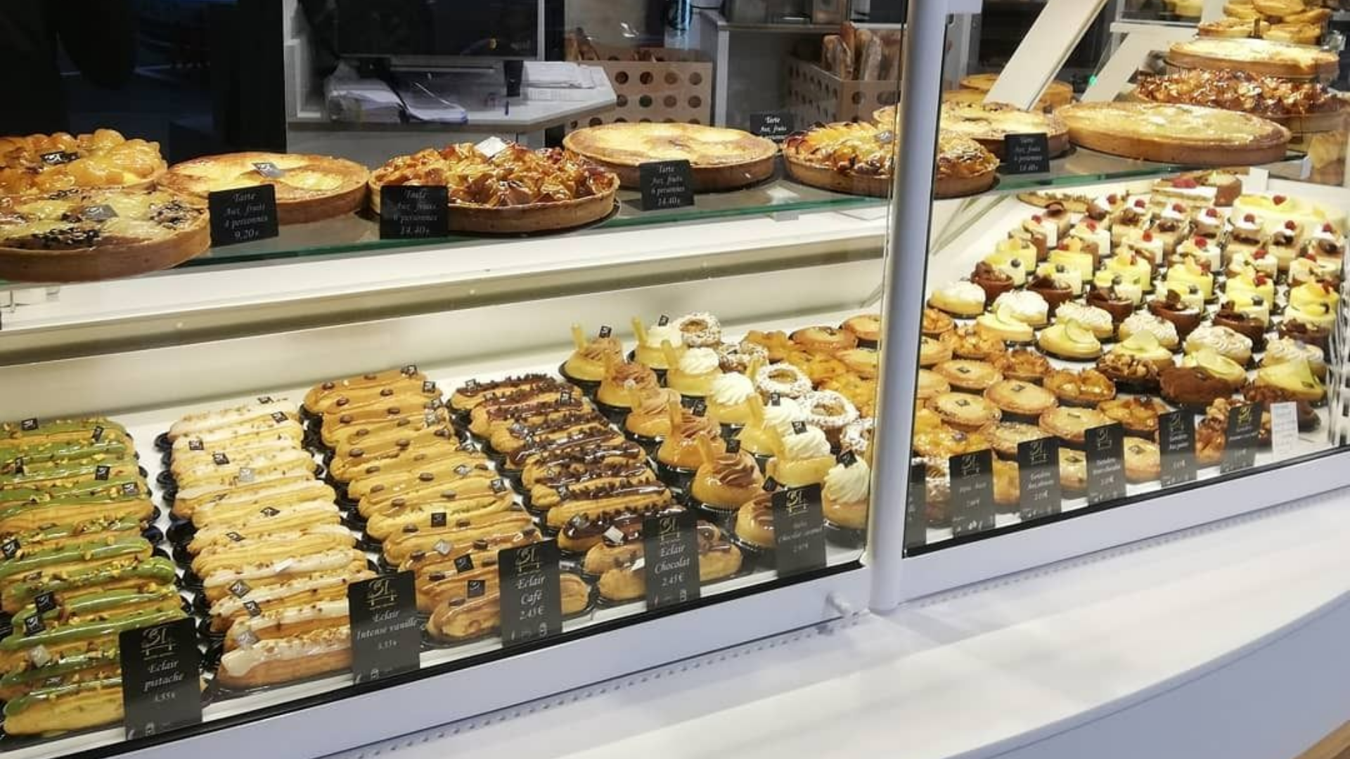 Vitrine de boulangerie présentant divers produits de boulangerie, notamment des tartes, des biscuits et des pâtisseries.